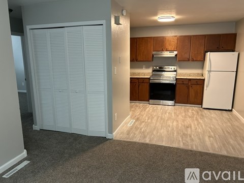 A kitchen with a white refrigerator and wooden cabinets.