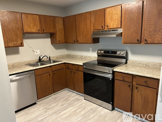 A kitchen with wooden cabinets and a black oven.