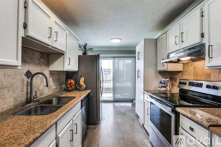 A kitchen with granite countertops and stainless steel appliances.
