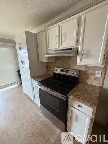A kitchen with white cabinets and a granite countertop.