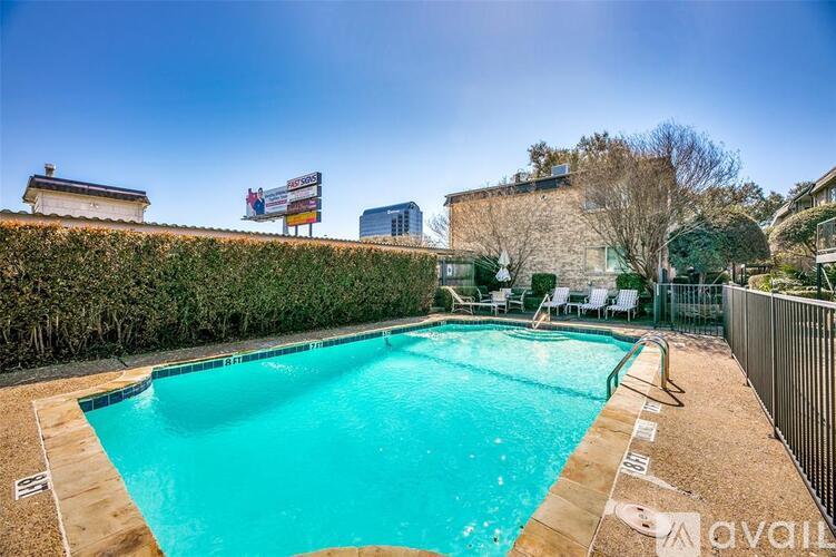 A swimming pool surrounded by a hedge and a fence.