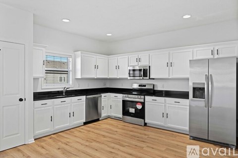 A kitchen with white cabinets and stainless steel appliances.