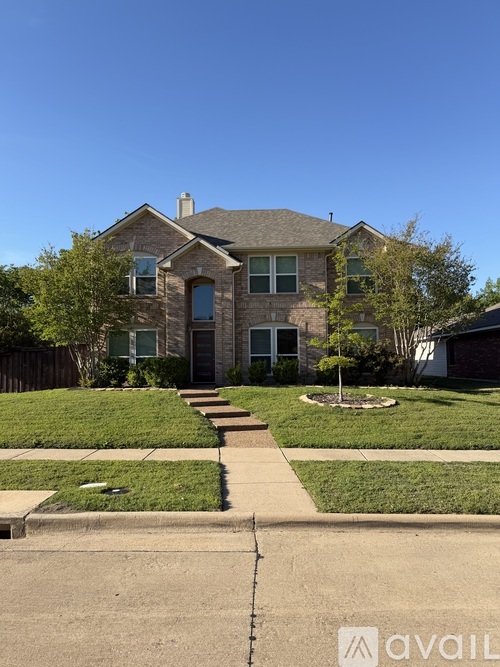 A house with a front yard and a tree.