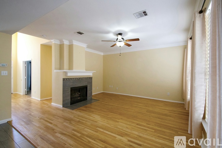A living room with a fireplace and a ceiling fan.