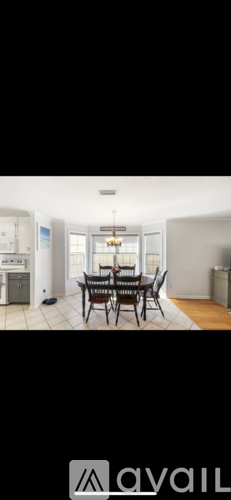 A dining room with a table and chairs.