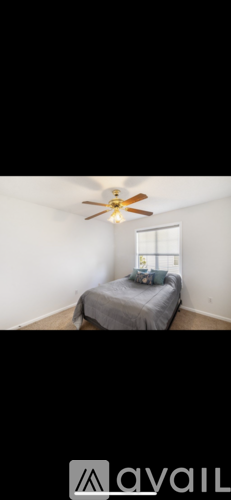A bedroom with a bed and a ceiling fan.