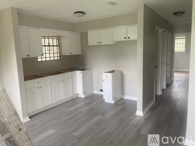 A kitchen with white cabinets and a window.