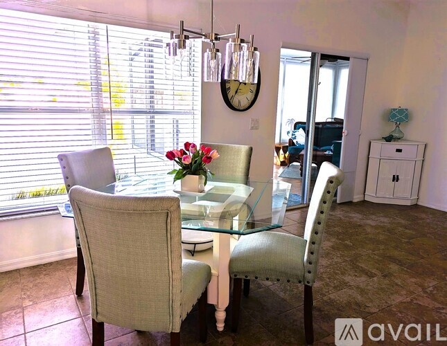 A dining room with a glass table and chairs.