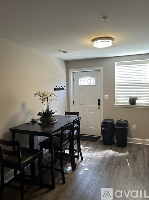 A dining room with a table and chairs.