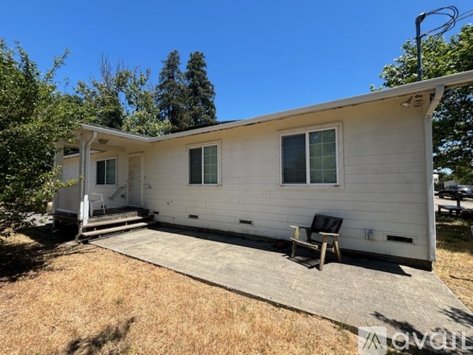 A white mobile home with a porch and a covered patio.