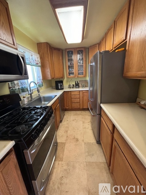 A kitchen with wooden cabinets and a black stove top oven.