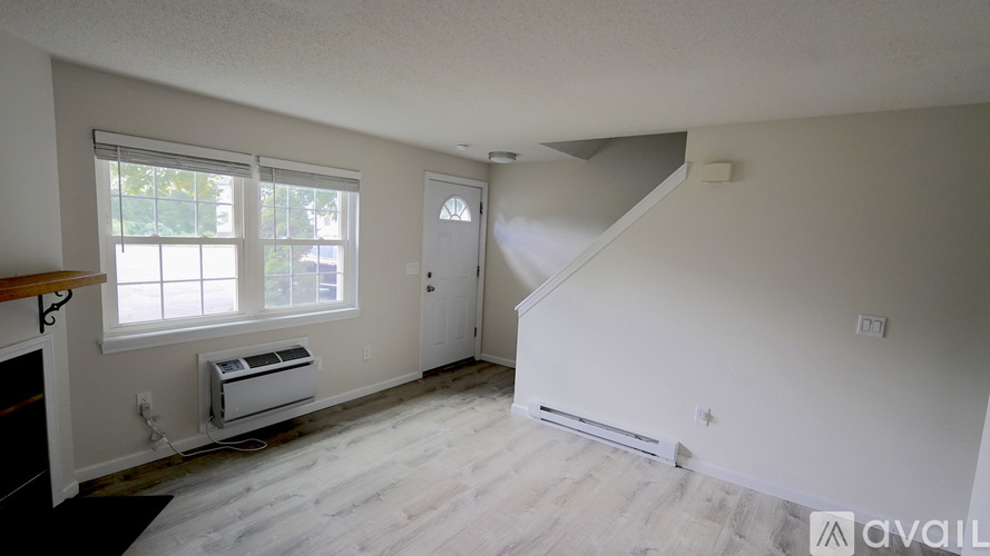 A room with a window, a door, and a staircase.