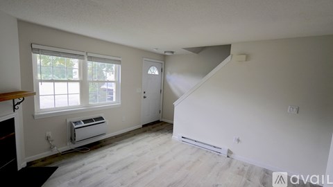 A room with a window, a door, and a staircase.
