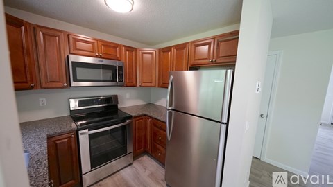 A kitchen with wooden cabinets and stainless steel appliances.