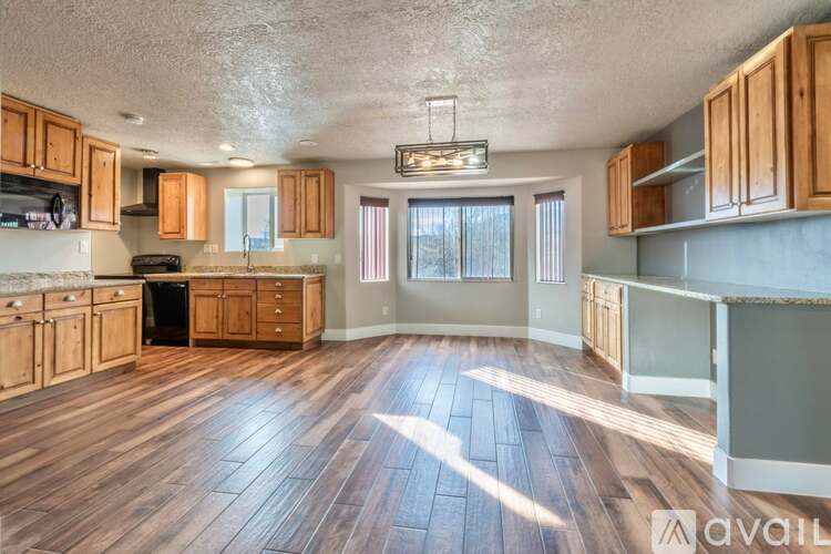 A kitchen with wooden cabinets and a black refrigerator.