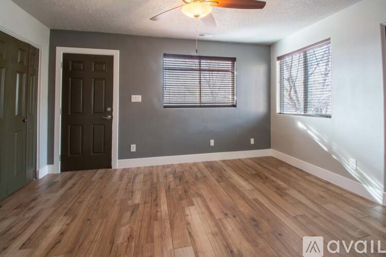 A room with wooden flooring and a ceiling fan.
