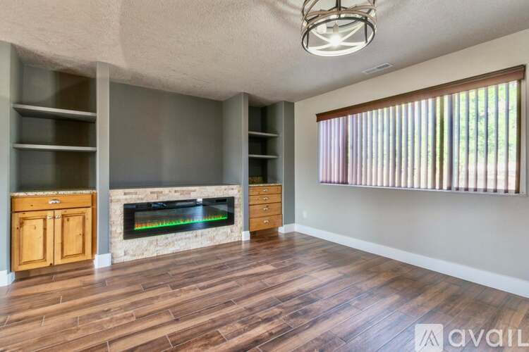 A living room with a fireplace and wooden floors.