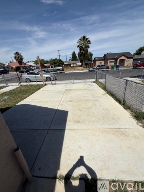 A shadow of a person holding a dog is cast on a concrete surface.