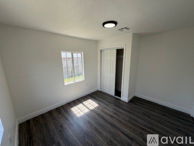 A room with a window and a door is available for rent.