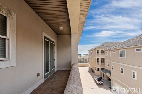A balcony with a view of a parking lot and other buildings.