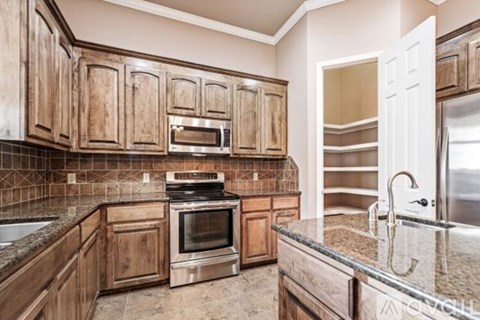 A kitchen with wooden cabinets and a granite countertop.