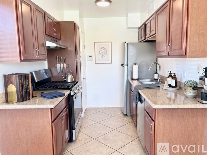A kitchen with wooden cabinets and a tiled floor.
