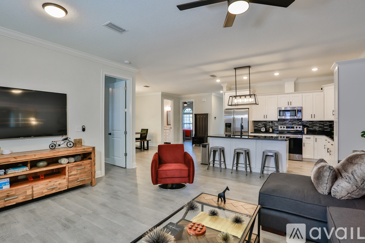 A modern living room with a red armchair and a wooden entertainment center.