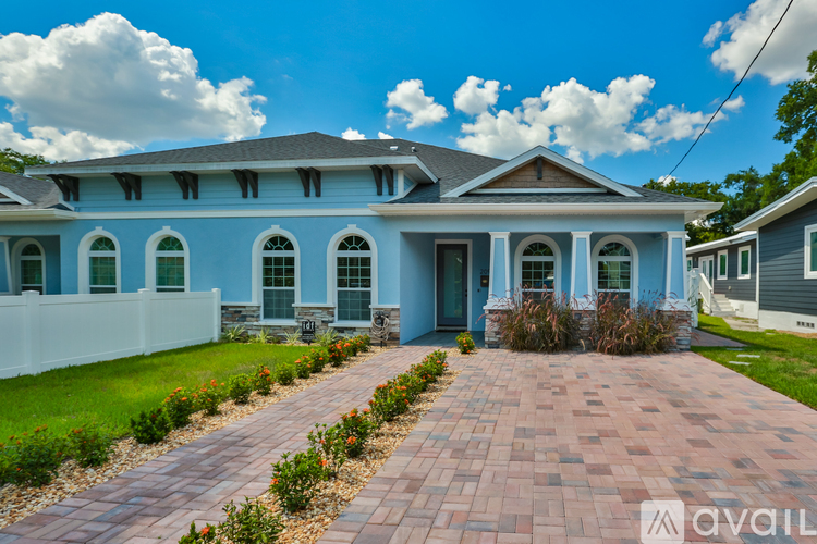 A blue house with a brick pathway leading to the front door.