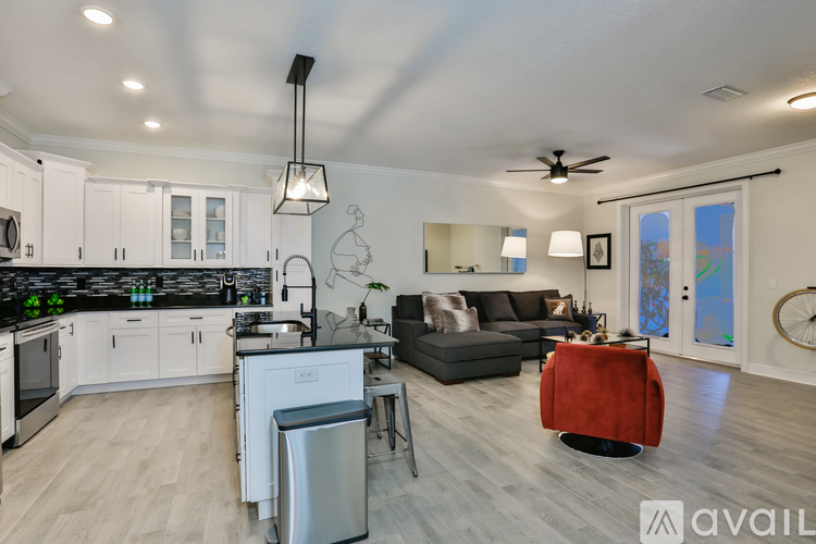 A modern kitchen with white cabinets and a black countertop.