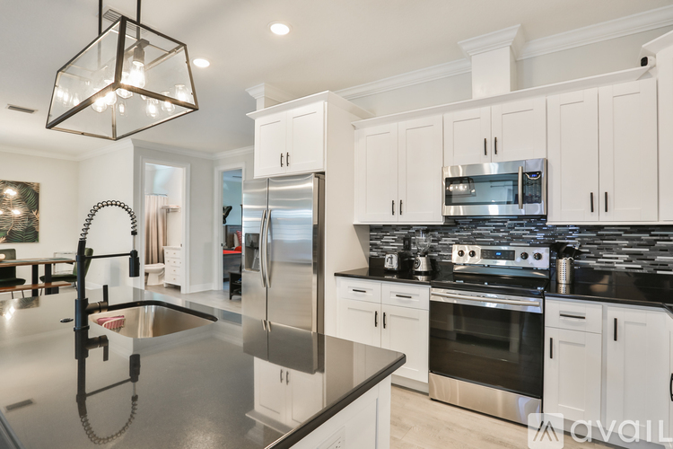 A modern kitchen with stainless steel appliances and white cabinets.
