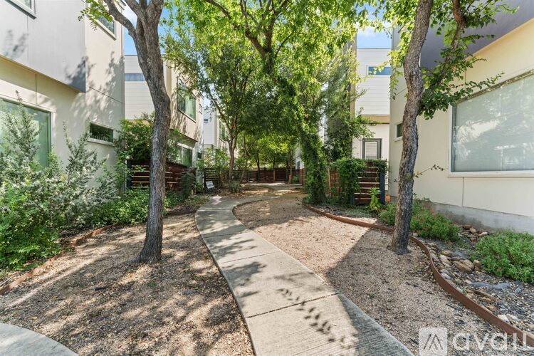 A tree-lined walkway leads through a courtyard.