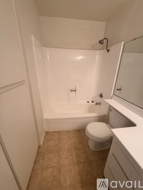 A small white bathroom with a toilet, sink, and bathtub.