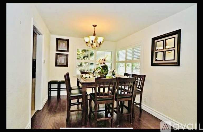 A dining room with a wooden table and chairs.