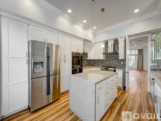 A modern kitchen with white cabinets and a central island.