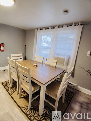 A dining room with a table and chairs.