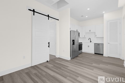 A kitchen with white cabinets and a wooden floor.
