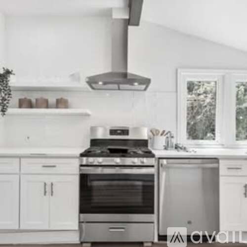 A modern kitchen with a stainless steel oven and range hood.