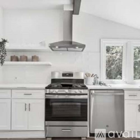 A modern kitchen with a stainless steel oven and range hood.
