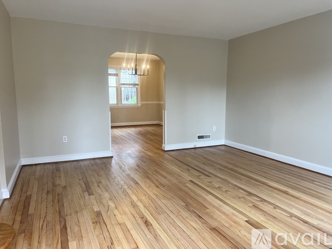 A room with wooden flooring and a window.