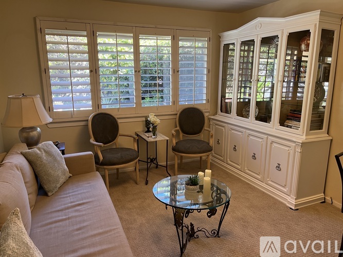 A living room with a couch, chairs, and a cabinet.