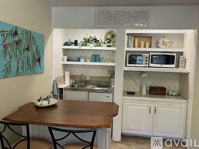 A kitchen with a table and chairs in front of it.