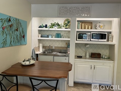 A kitchen with a table and chairs in front of it.