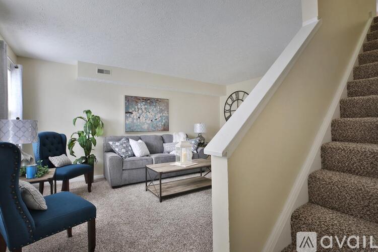 A living room with a blue chair and a grey couch.