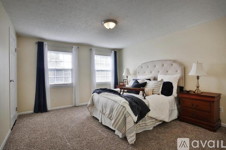 A bedroom with a large bed and a carpeted floor.