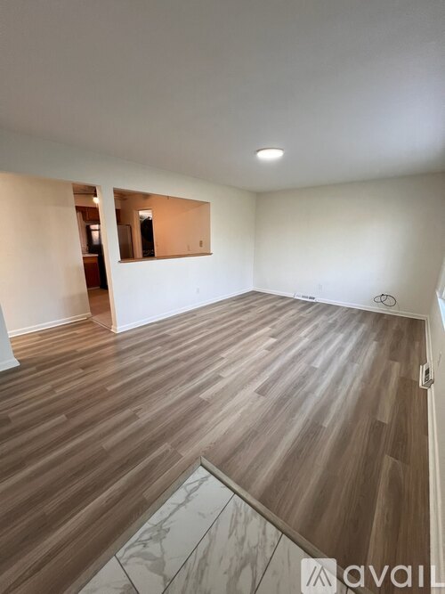 A room with wooden flooring and a mirror on the wall.
