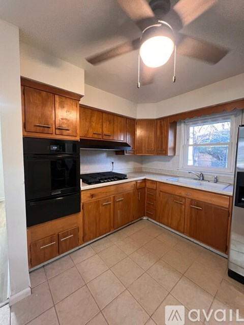 A kitchen with wooden cabinets and a black oven.