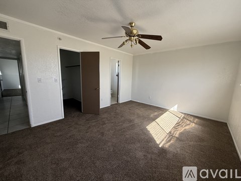 A room with a ceiling fan and carpeted floor.