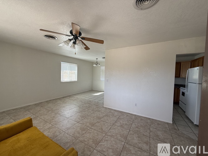 A living room with a yellow couch and a ceiling fan.