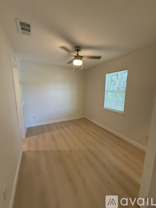A room with a ceiling fan and a window.