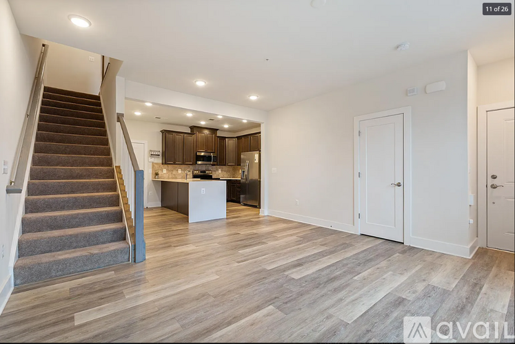 A spacious living room with a staircase leading to the upper floor.